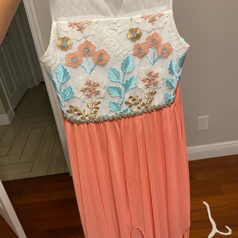 A white and pink dress with flowers and lace on top.